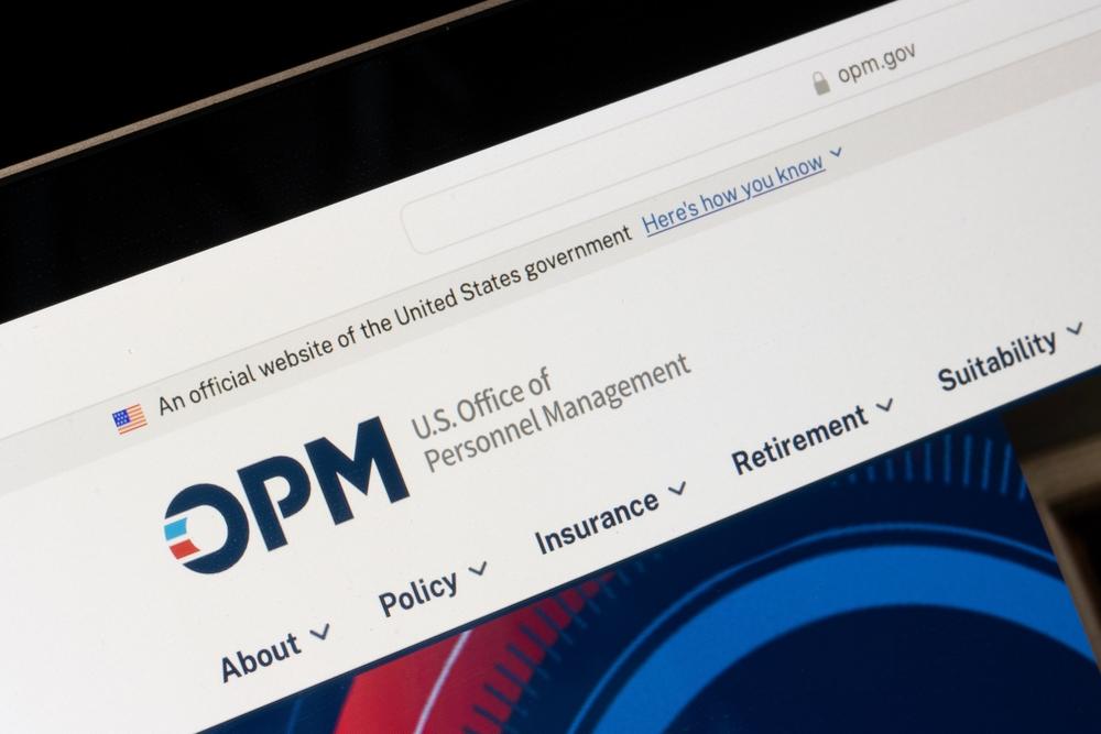 The OPM website open on a laptop screen, showing the U.S. Office of Personnel Management menu
